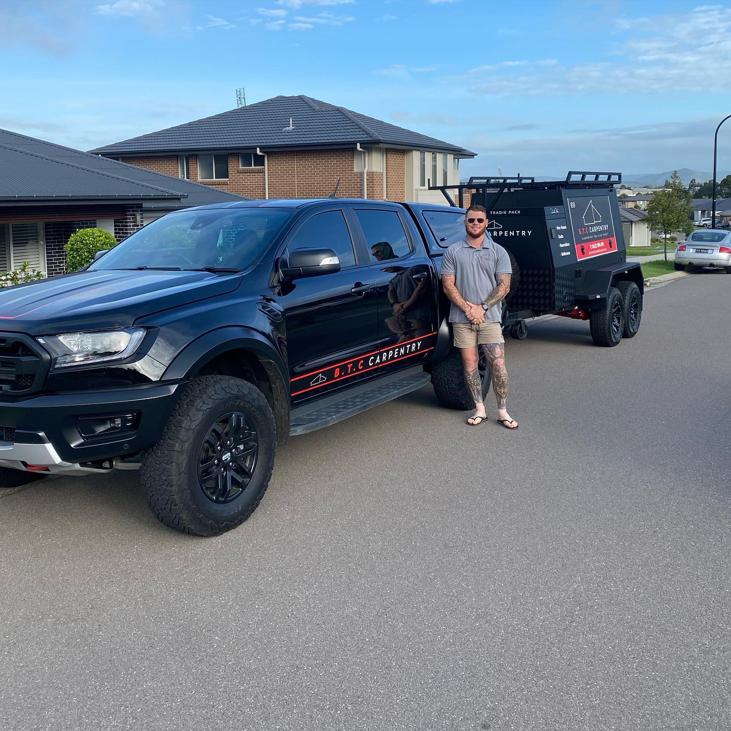 BTC Carpentry builder standing beside the company ute and work trailer